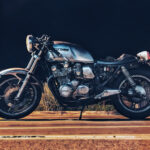 Silver motorcycle parked at night outdoors.